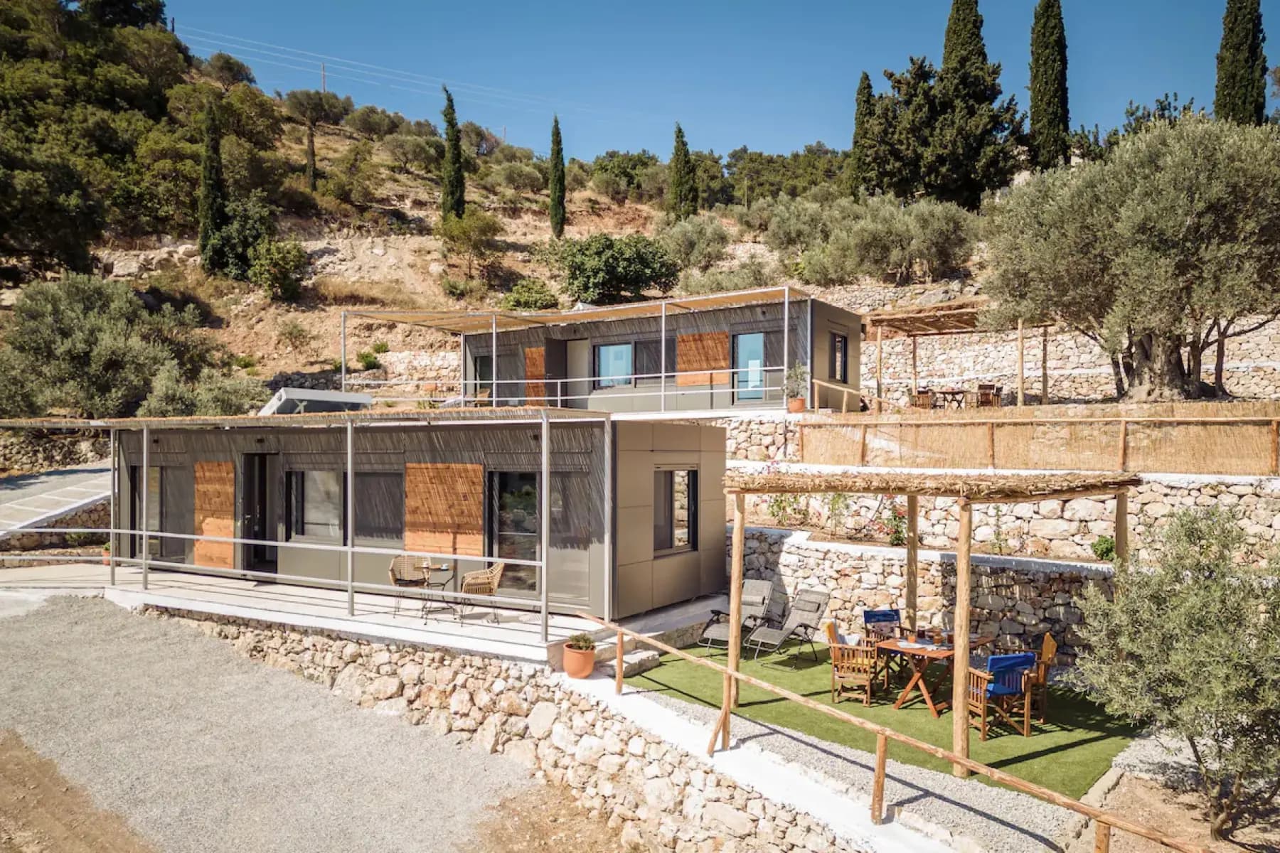 Κατοικίες Easy Boxes σε πλαγιά με πέτρινες πεζούλες και ελιές